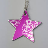 Reverse of bright pink star pendant hand crafted from anodised aluminium and printed with a silvery coloured print of an aster flower displayed on a silver chain