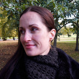 Gold plated silver roses stud earrings by Sally Lees worn by model in the park
