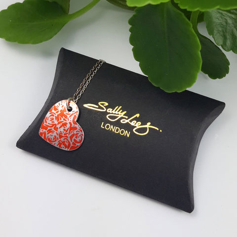 Orange roses heart shaped pendant displayed on a black gift ox with a gold Sally Lees logo