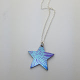 Reverse side of this star pendant on a sterling silver chain. This is the back of this star pendant which is also printed with an of centre section of a chrysanthemum flower in blue with a purple and blue background.