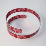 Anodised aluminium wrap around cuff with prints of carnations both on the inside and outside.