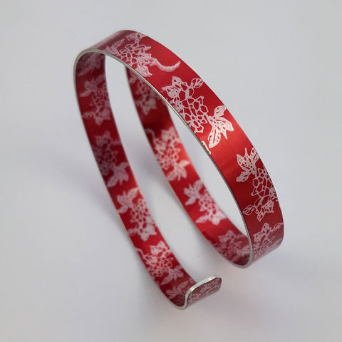 REd anodiszed aluminum cuff printed with carnations.