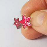 Red star shaped poinsettia stud earrings for December birthdays displayed on o
